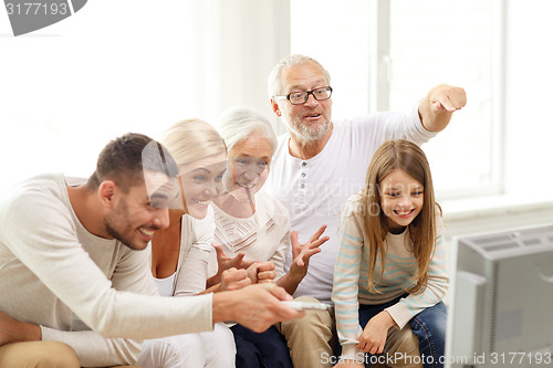 Image of happy family watching tv at home
