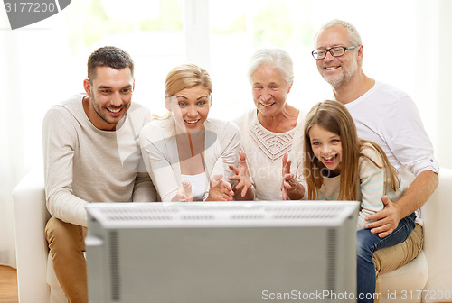 Image of happy family watching tv at home