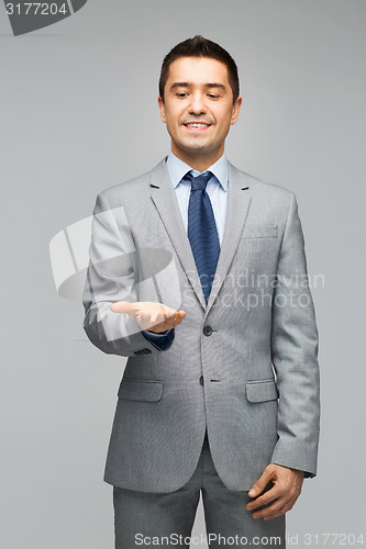 Image of happy businessman in suit showing empty palms