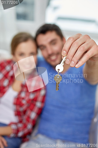 Image of close up of happy couple showing key at home
