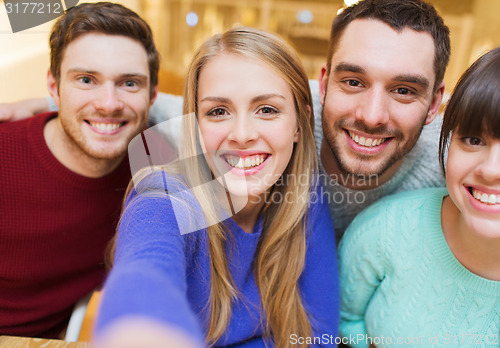 Image of group of smiling friends taking selfie