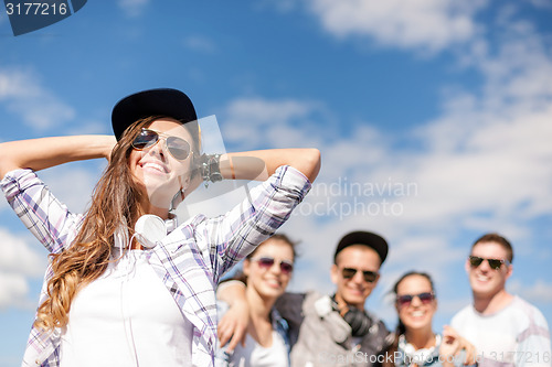 Image of teenage girl with headphones and friends outside