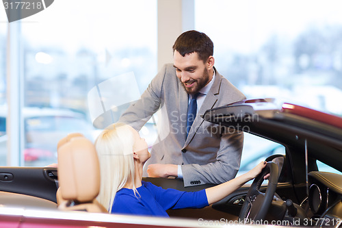 Image of happy couple buying car in auto show or salon