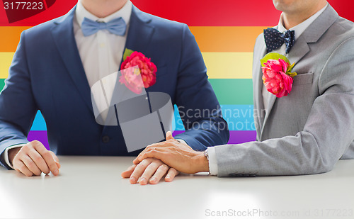 Image of close up of happy male gay couple holding hands