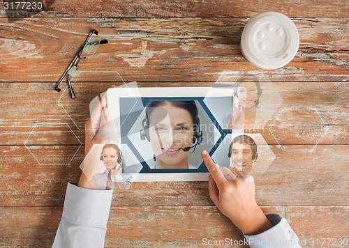 Image of close up of hands with tablet pc and helpline