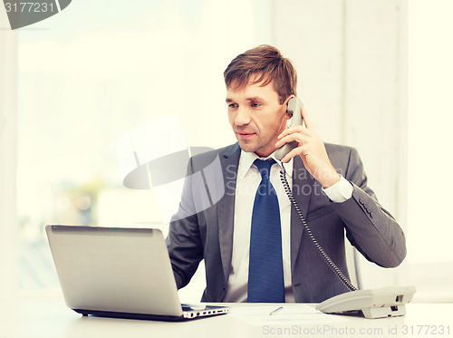 Image of businessman with laptop computer and phone