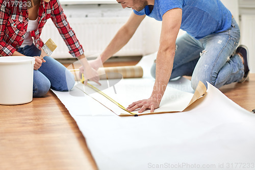 Image of close up of couple measuring wallpaper