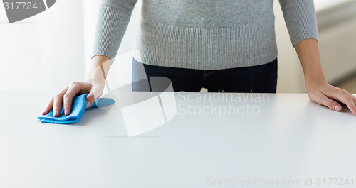 Image of close up of woman cleaning table with cloth