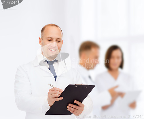 Image of smiling male doctor with clipboard