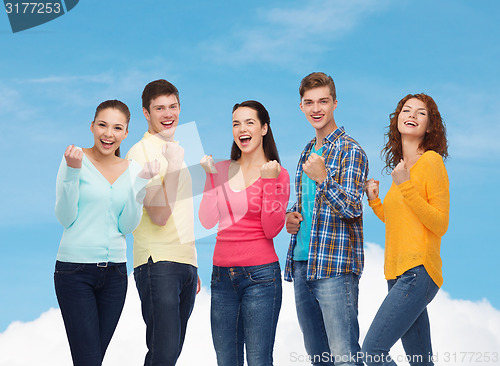 Image of group of smiling teenagers showing triumph gesture