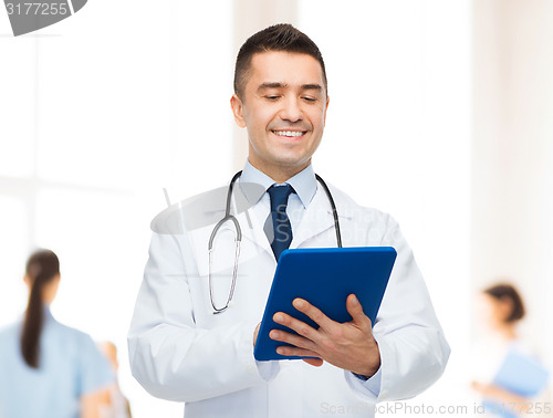 Image of smiling male doctor with tablet pc at hospital