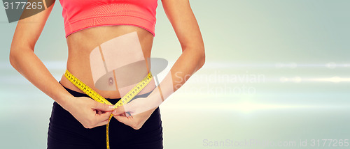 Image of close up of female hands measuring waist