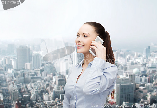 Image of young smiling businesswoman with smartphone