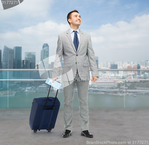 Image of happy businessman in suit with travel bag