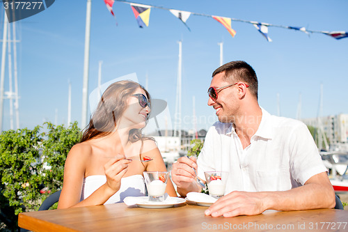 Image of smiling couple eating dessert at cafe