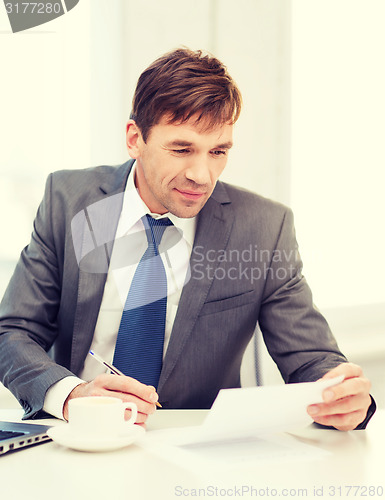 Image of businessman with laptop computer and documents