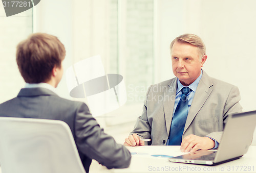 Image of older man and young man having meeting in office