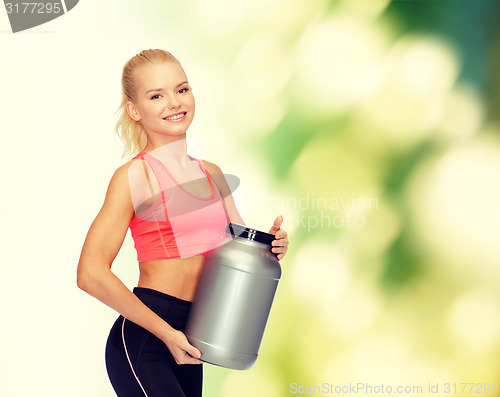 Image of smiling sporty woman with jar of protein