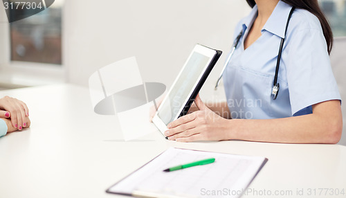 Image of close up of doctor showing x-ray on tablet pc