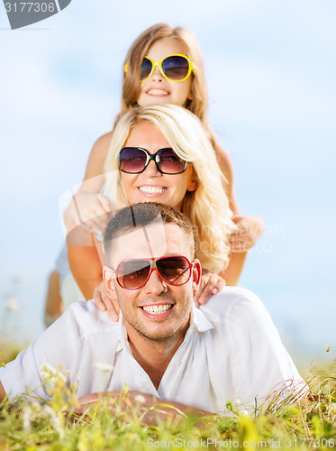 Image of happy family with blue sky and green grass