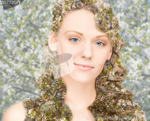 Image of happy young woman over blooming tree pattern