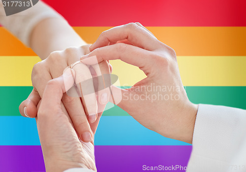 Image of close up of lesbian couple hands with wedding ring