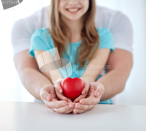 Image of close up of man and girl holding red heart shape