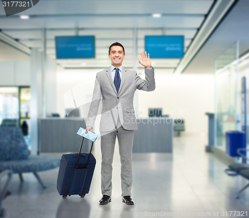 Image of happy businessman in suit with travel bag