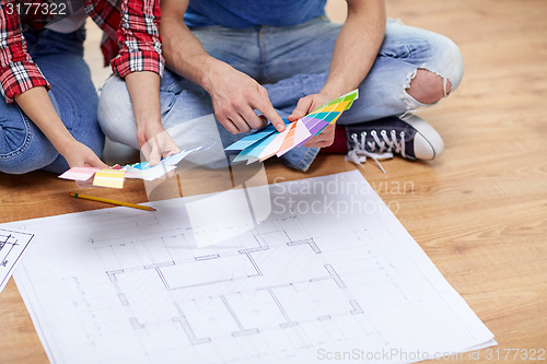 Image of close up of couple with blueprint and palettes