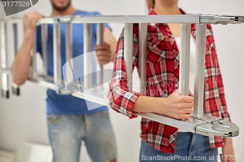 Image of close up of couple carrying ladder together