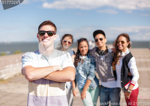 Image of teenage boy with sunglasses and friends outside