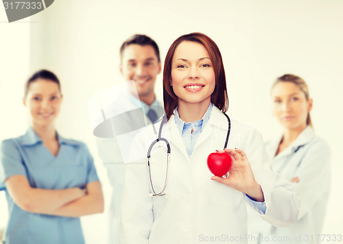 Image of smiling female doctor with heart and stethoscope