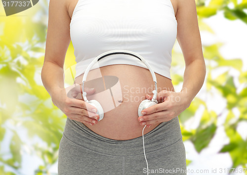 Image of close up of pregnant woman and headphones on tummy