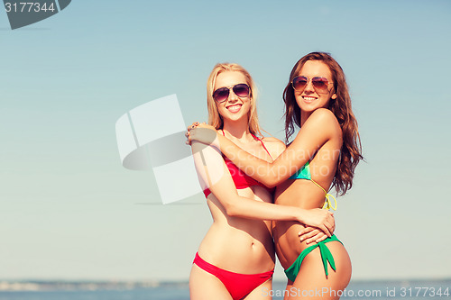 Image of two smiling young women on beach