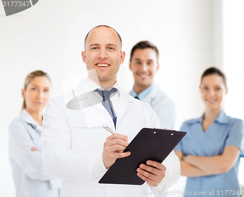 Image of smiling male doctor with clipboard