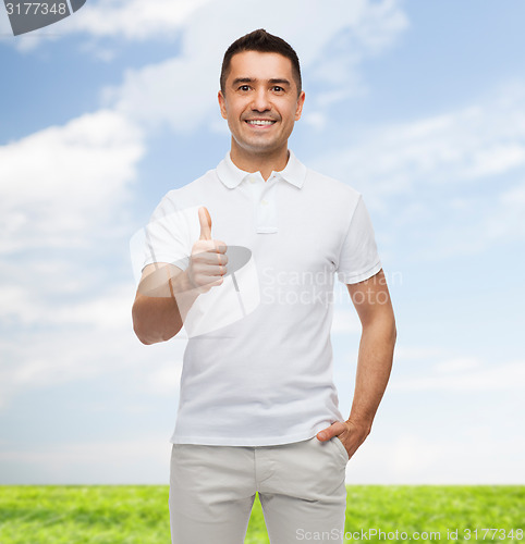 Image of smiling man in white t-shirt showing thumbs up