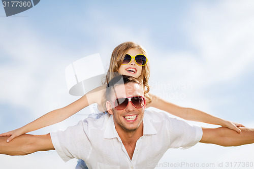 Image of happy father and child in sunglasses over blue sky