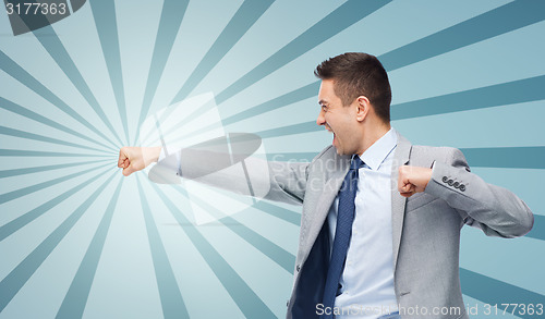 Image of businessman in suit fighting with someone