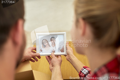 Image of close up of happy couple looking at family photo