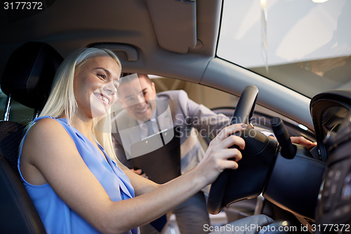 Image of happy woman with car dealer in auto show or salon