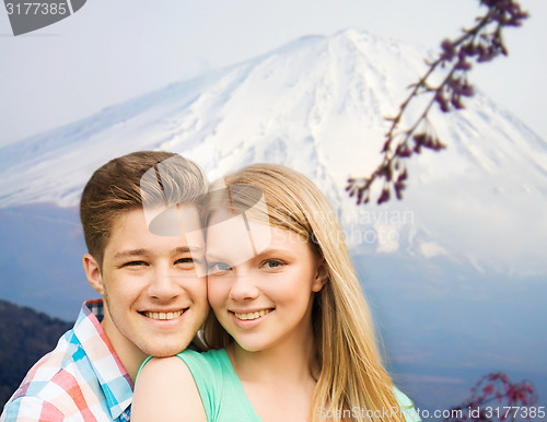 Image of smiling couple hugging over mountains background