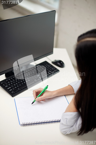 Image of close up of sad woman with computer and notebook