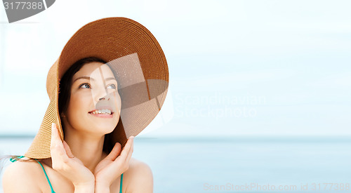 Image of girl in hat standing on the beach