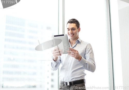 Image of smiling businessman with tablet pc in office