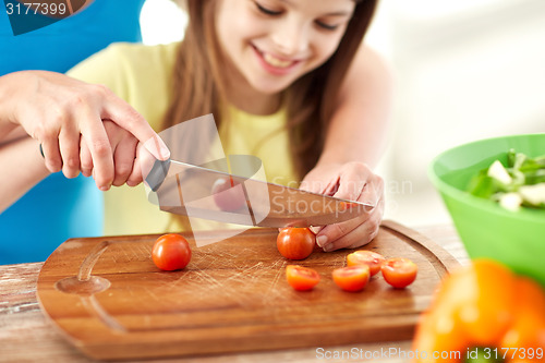 Image of close up of happy family making dinner in kitchen