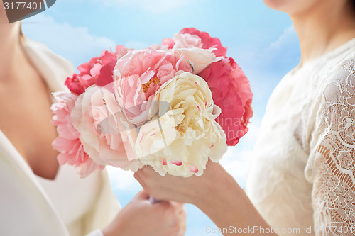 Image of close up of happy lesbian couple with flowers