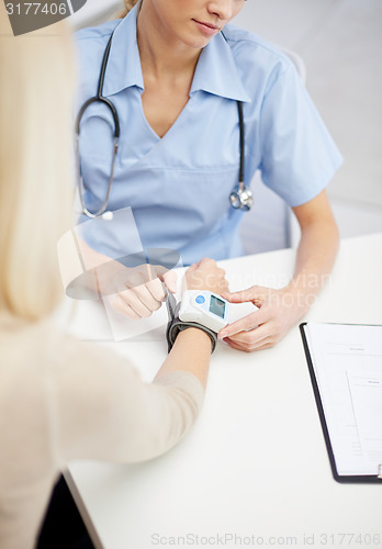 Image of close up of doctor measuring pulse to patient