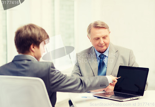 Image of older man and young man with laptop computer