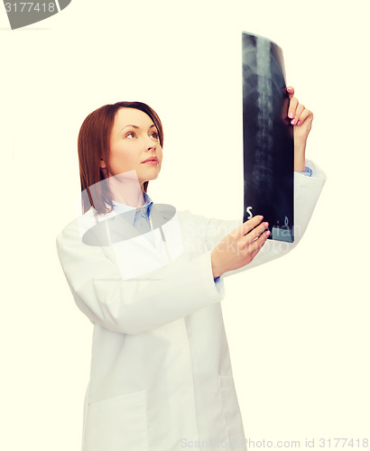 Image of serious female doctor looking at x-ray