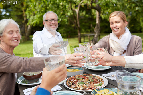 Image of happy family having dinner in summer garden